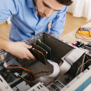 Technician repairing a desktop computer, changing circuit board